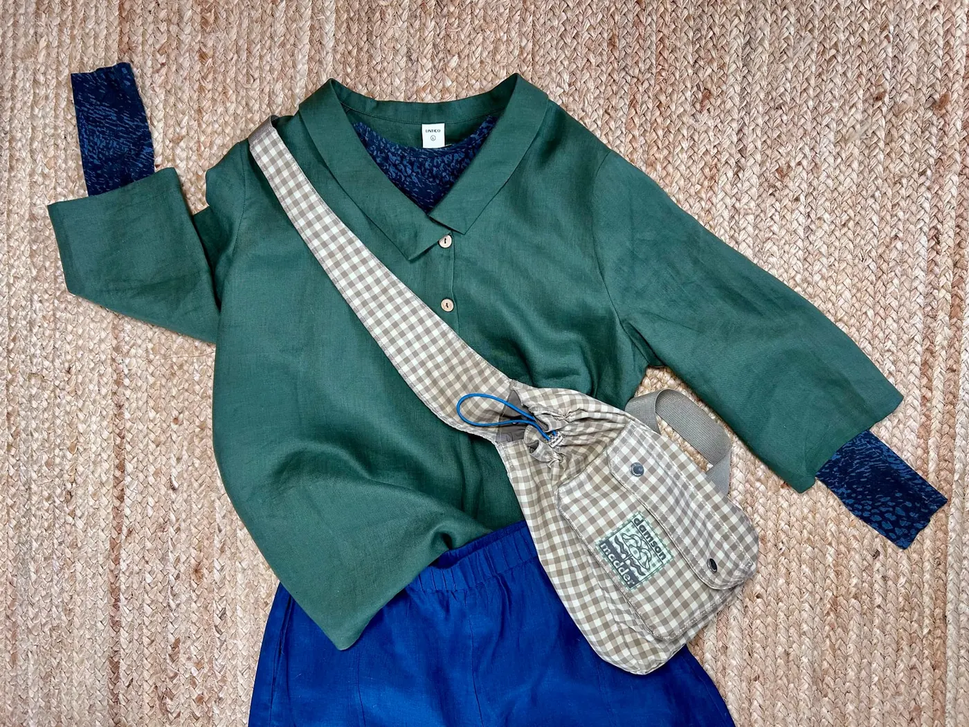 Olive green tunic with blue trousers and a gingham crossbody bag