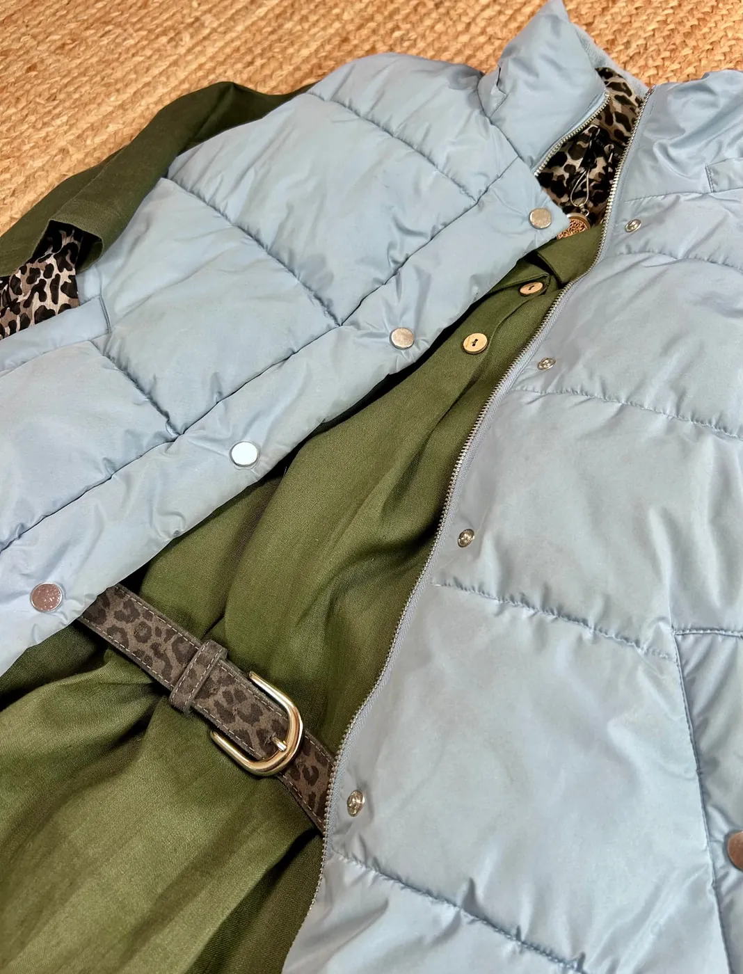 Pale blue puffer gilet laid over olive green and animal-print layers
