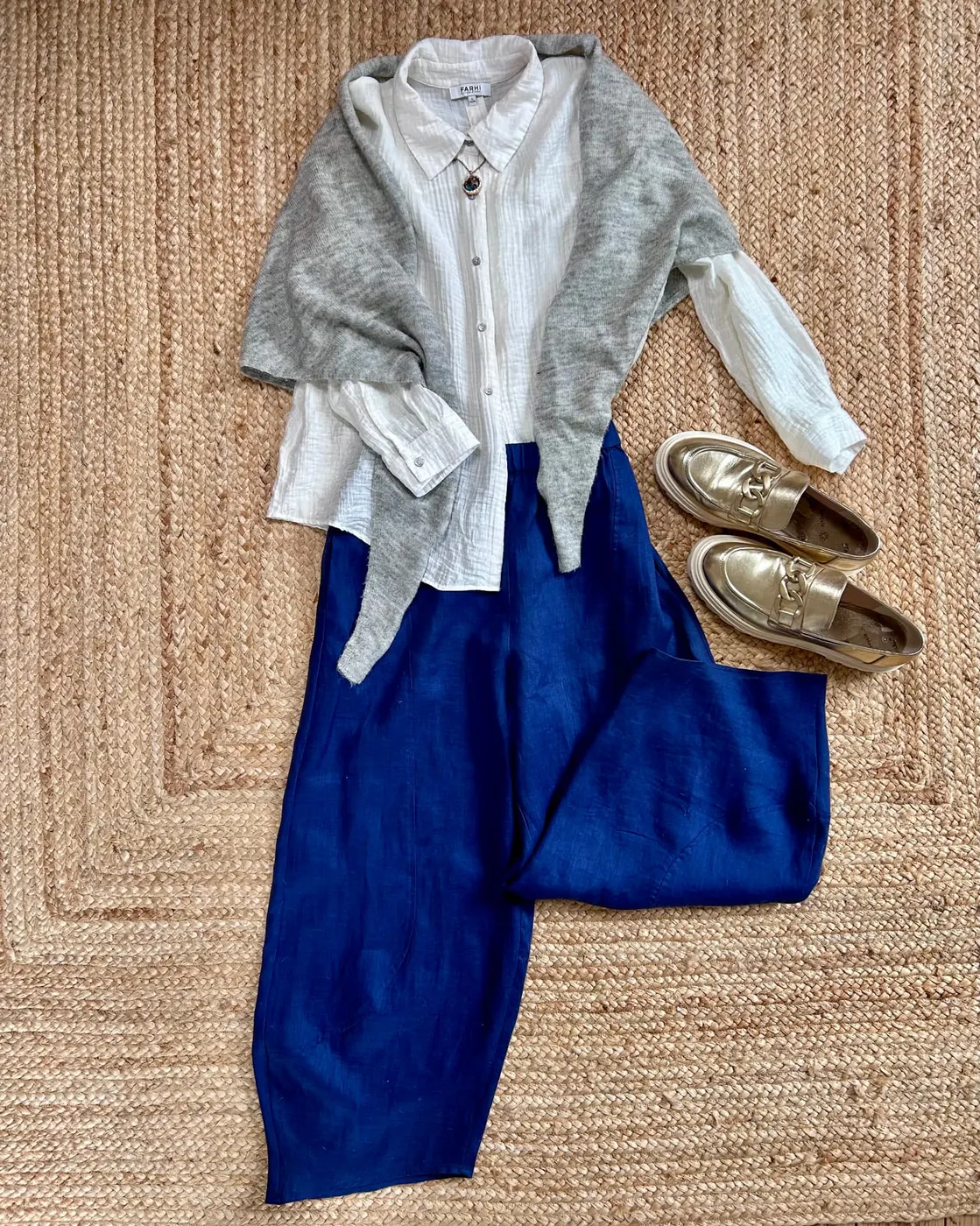 Blue linen trousers with a white shirt, grey cardigan and gold shoes